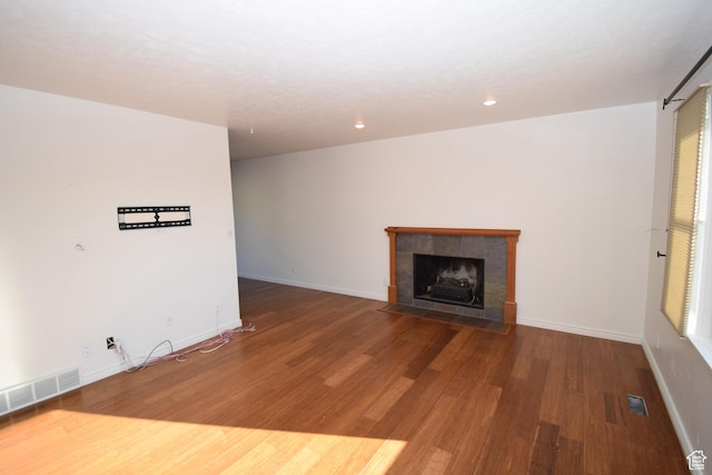 9111 S Parakeet Dr, Sandy, UT 84093 - unfurnished living room featuring baseboards, recessed lighting, a tiled fireplace, visible vents, and wood finished floors