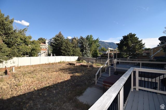 9111 S Parakeet Dr, Sandy, UT 84093 - view of yard with a deck with mountain view, a fenced backyard, and a vegetable garden