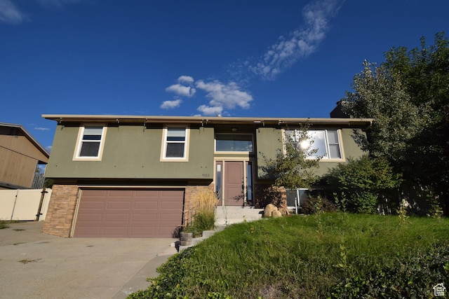 9111 S Parakeet Dr, Sandy, UT 84093 - split foyer home with driveway, stucco siding, and an attached garage