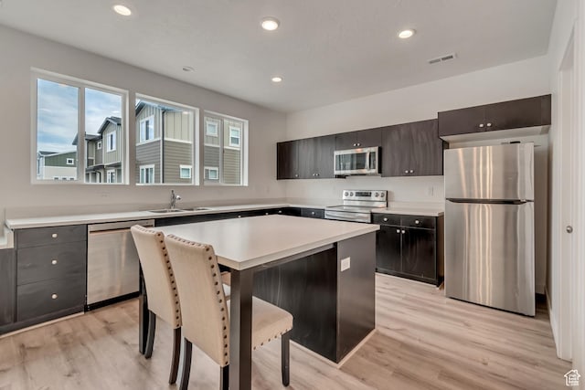 kitchen featuring light wood-type flooring, appliances with stainless steel finishes, a sink, and visible vents