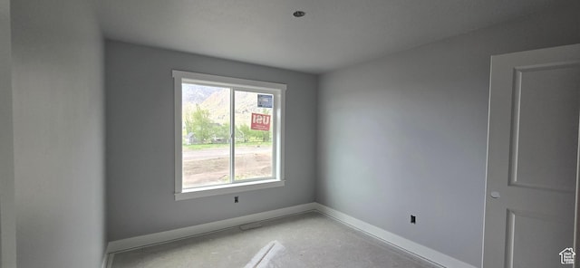 empty room with a wealth of natural light and baseboards