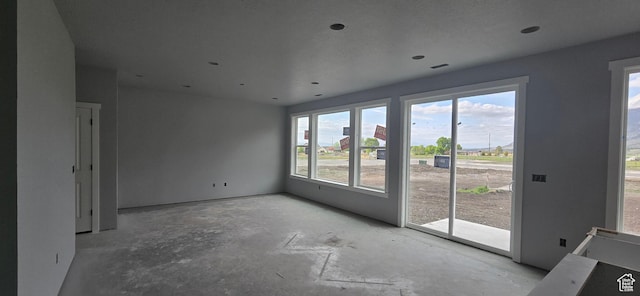 empty room featuring plenty of natural light and unfinished concrete floors