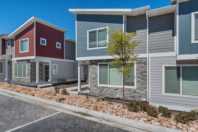 view of front of home featuring uncovered parking and stone siding