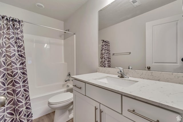 bathroom featuring visible vents, shower / bath combination with curtain, toilet, vanity, and wood finished floors