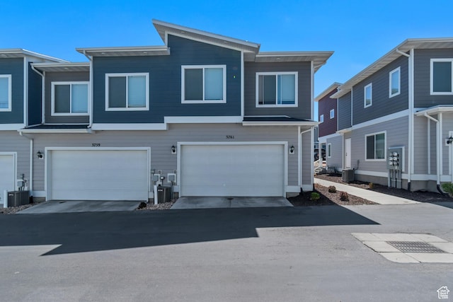 townhome / multi-family property featuring an attached garage and cooling unit