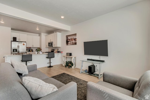 living area with light wood-type flooring and recessed lighting