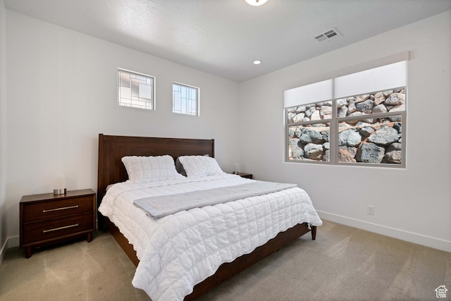 bedroom with light carpet, recessed lighting, visible vents, and baseboards