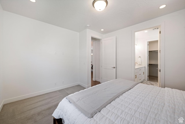 bedroom featuring baseboards, recessed lighting, ensuite bath, visible vents, and light colored carpet