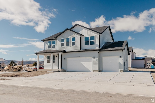 view of front of property featuring an attached garage, concrete driveway, board and batten siding, and a mountain view