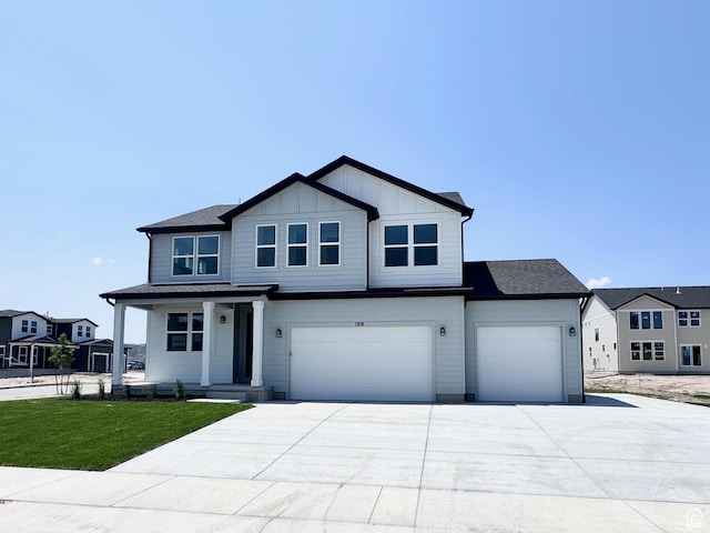109 N Blue Mountain Dr Unit 208, Saratoga Springs, UT 84043 - view of front of property with concrete driveway, a front yard, a garage, covered porch, and board and batten siding