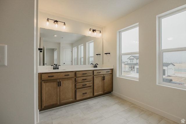 bathroom featuring double vanity, baseboards, and tile patterned flooring