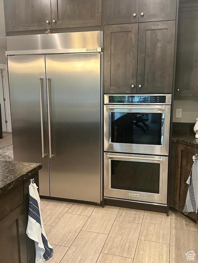 210 S 350 W, Bountiful, UT 84010 - kitchen featuring dark brown cabinets, light wood-type flooring, stainless steel appliances, and dark stone countertops
