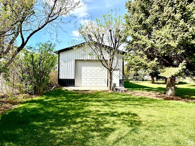 view of grassy yard with a detached garage and an outdoor structure