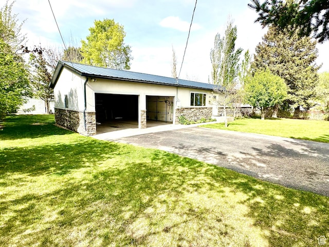 view of side of home featuring stone siding, asphalt driveway, stucco siding, and a yard
