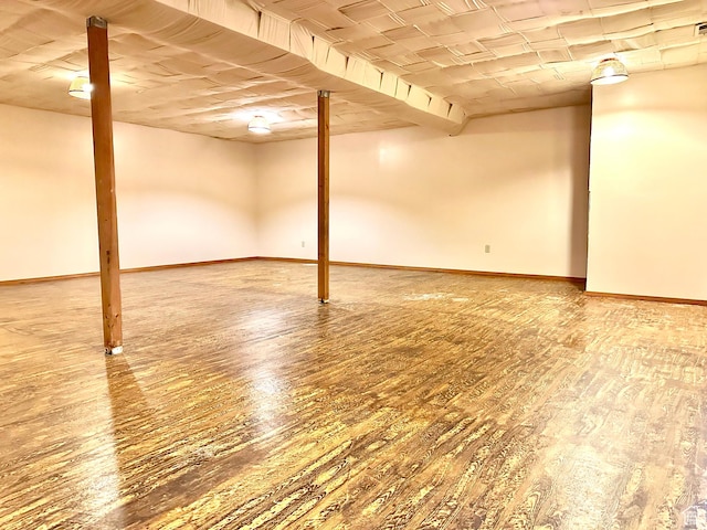 finished below grade area featuring wood finished floors and baseboards