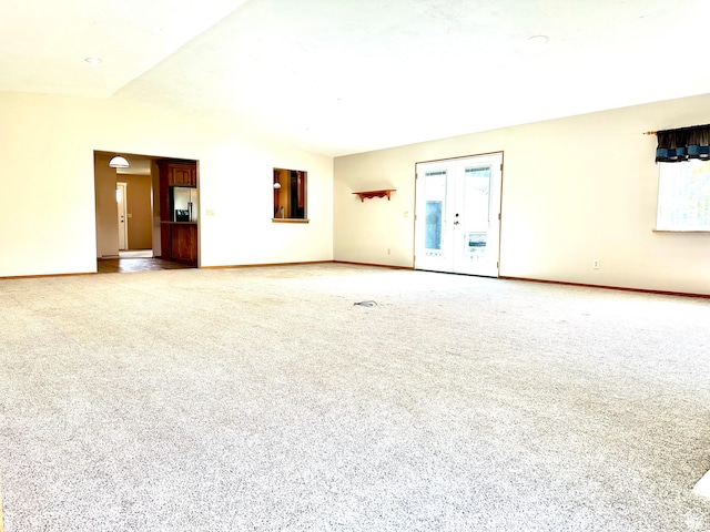 unfurnished living room with light colored carpet and baseboards