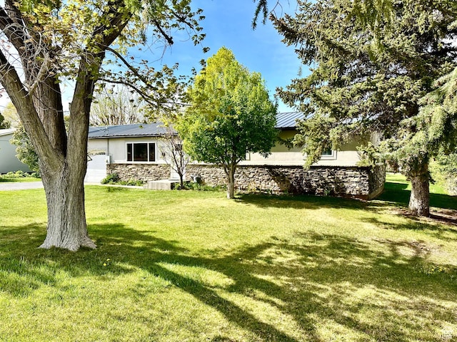 view of grassy yard with a garage