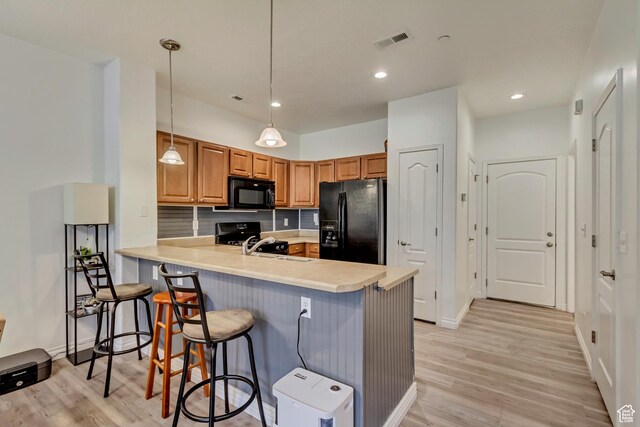 24 S 1520 W, Pleasant Grove, UT 84062 - kitchen featuring a peninsula, light wood-style floors, visible vents, a kitchen bar, and black appliances