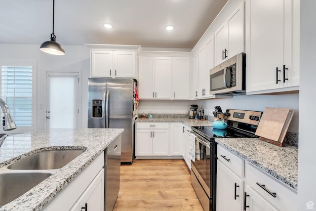 4434 W Glendon Dr, Lehi, UT 84043 - kitchen featuring white cabinets, light wood-style flooring, a sink, stainless steel appliances, and decorative light fixtures