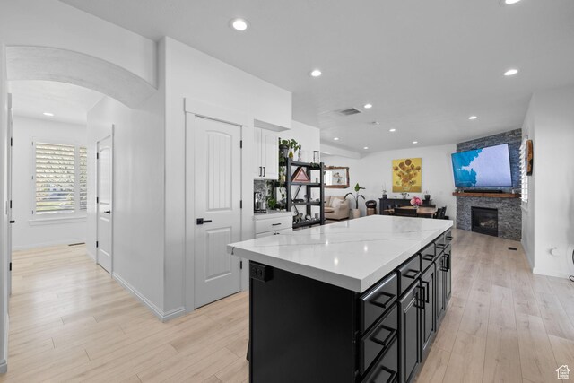 4634 W Baldy Dr, West Jordan, UT 84088 - kitchen featuring light countertops, dark cabinets, arched walkways, open floor plan, and a kitchen island