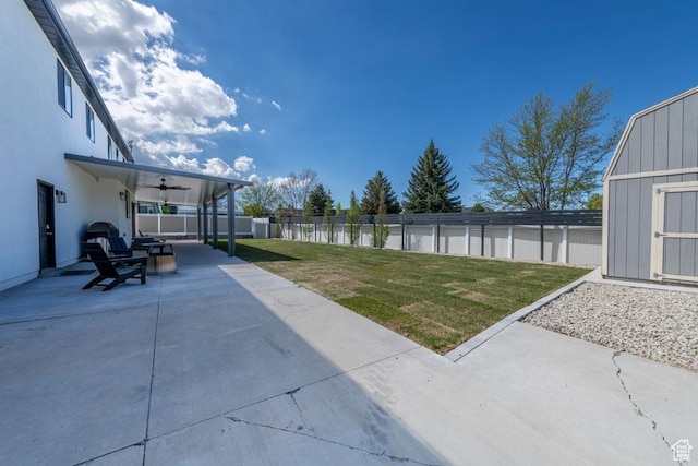 4634 W Baldy Dr, West Jordan, UT 84088 - view of yard with ceiling fan, a fenced backyard, a storage unit, a patio area, and an outbuilding