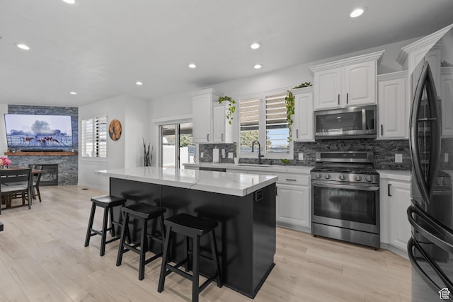 4634 W Baldy Dr, West Jordan, UT 84088 - kitchen featuring decorative backsplash, a kitchen breakfast bar, a center island, a sink, and stainless steel appliances