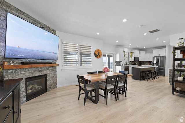 4634 W Baldy Dr, West Jordan, UT 84088 - dining space with visible vents, recessed lighting, light wood-style floors, and a stone fireplace