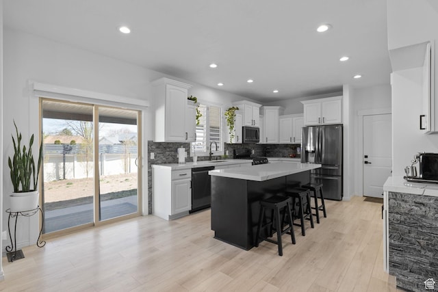 4634 W Baldy Dr, West Jordan, UT 84088 - kitchen with stainless steel fridge, a sink, a breakfast bar area, black dishwasher, and range with gas cooktop