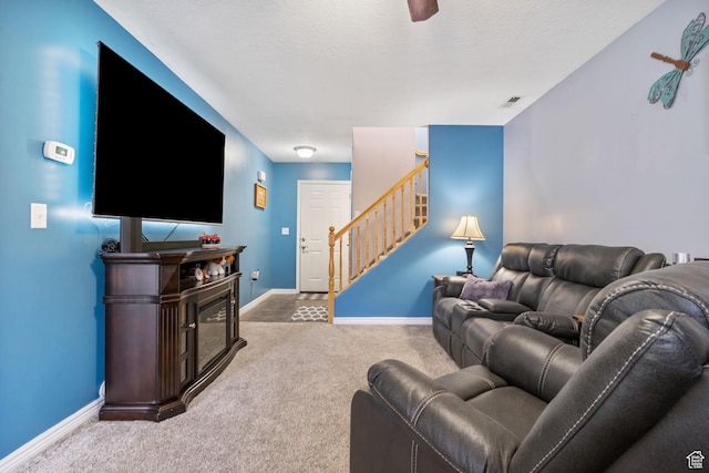 carpeted living room featuring stairway, visible vents, and baseboards