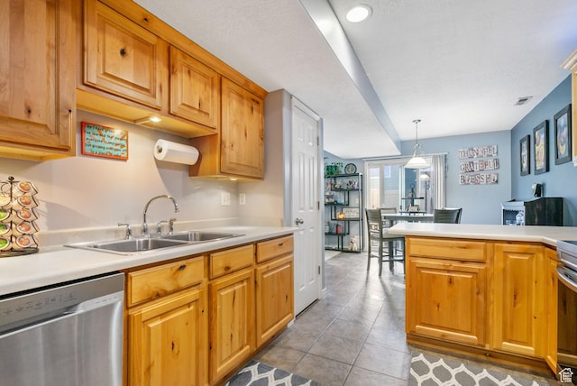 kitchen with light tile patterned floors, dishwasher, light countertops, and a sink