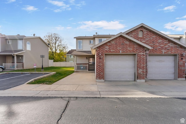 traditional-style home with driveway, a garage, fence, and brick siding