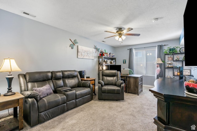 carpeted living area featuring visible vents, a textured ceiling, and ceiling fan
