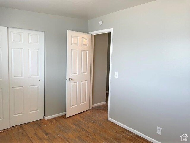unfurnished bedroom with wood finished floors and baseboards