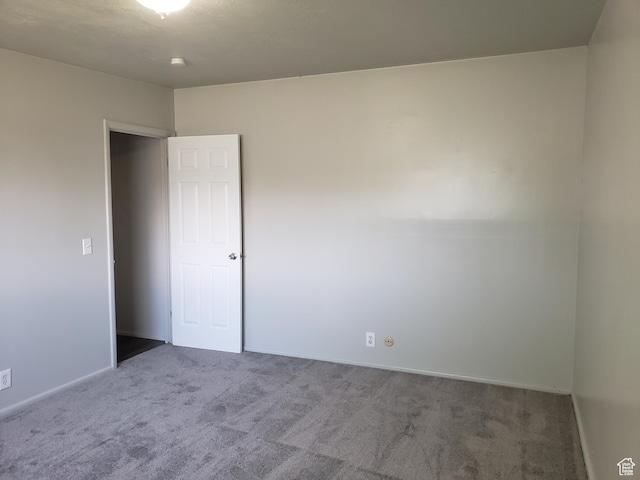unfurnished room with baseboards and carpet floors
