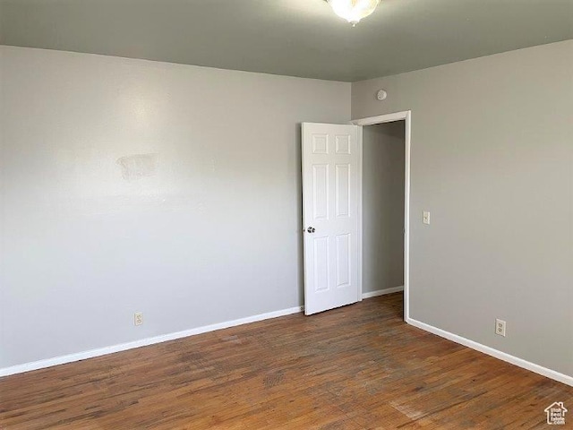 empty room with baseboards and wood finished floors