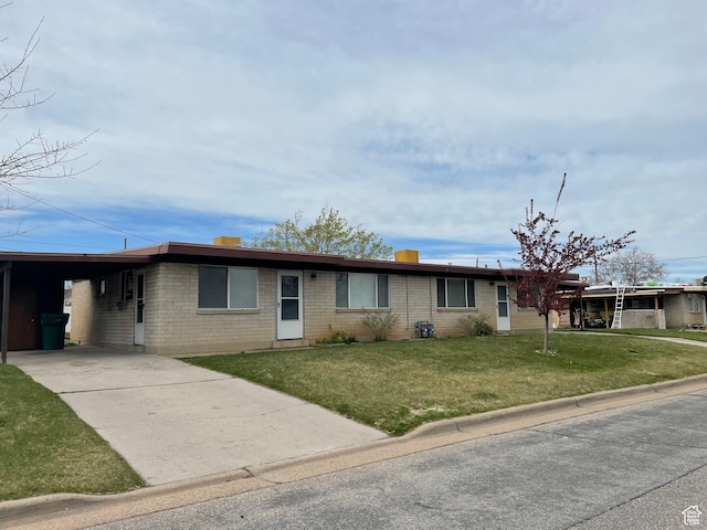 ranch-style house featuring concrete driveway, a front yard, brick siding, and a carport