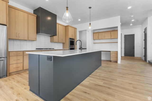4125 N Maple Blvd W Unit 119, Lehi, UT 84043 - kitchen featuring an island with sink, tasteful backsplash, appliances with stainless steel finishes, light countertops, and light wood-style floors