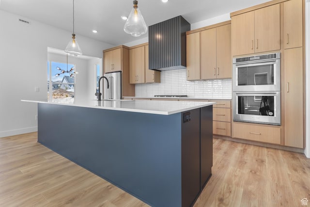 4125 N Maple Blvd W Unit 119, Lehi, UT 84043 - kitchen with stainless steel appliances, an island with sink, light brown cabinetry, light countertops, and decorative backsplash