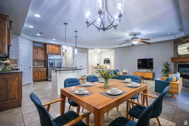 dining area featuring recessed lighting, arched walkways, a fireplace, and ceiling fan with notable chandelier