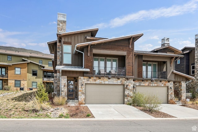 view of front facade with concrete driveway, stone siding, an attached garage, and board and batten siding