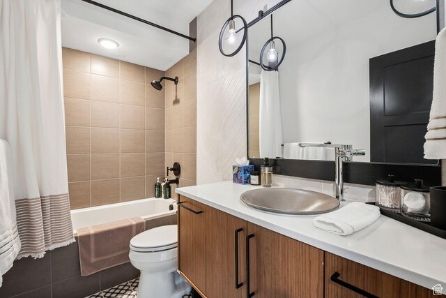 bathroom with tile patterned floors, shower / bathtub combination with curtain, vanity, and toilet