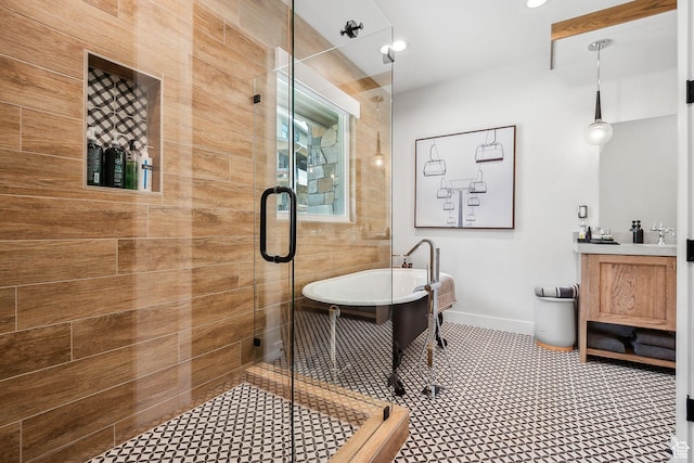 full bath with a stall shower, a freestanding tub, and vanity