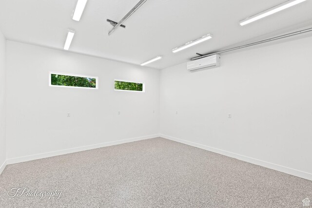 spare room with a wall unit AC and baseboards
