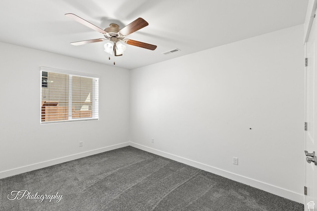 unfurnished room with dark carpet, visible vents, baseboards, and a ceiling fan