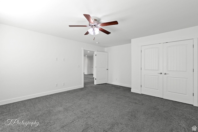 unfurnished bedroom featuring a closet, baseboards, dark carpet, and ceiling fan