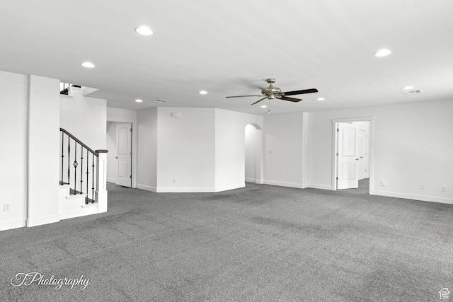 unfurnished living room featuring baseboards, arched walkways, a ceiling fan, recessed lighting, and stairway