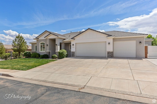 view of front facade with concrete driveway, stucco siding, a front yard, a tile roof, and a garage