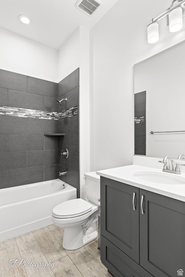 full bathroom with visible vents, toilet, bathtub / shower combination, vanity, and wood finished floors