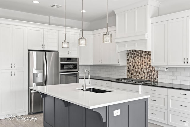 kitchen with a sink, visible vents, appliances with stainless steel finishes, and white cabinetry