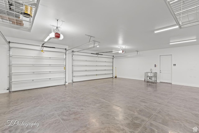 garage with a sink, baseboards, and a garage door opener